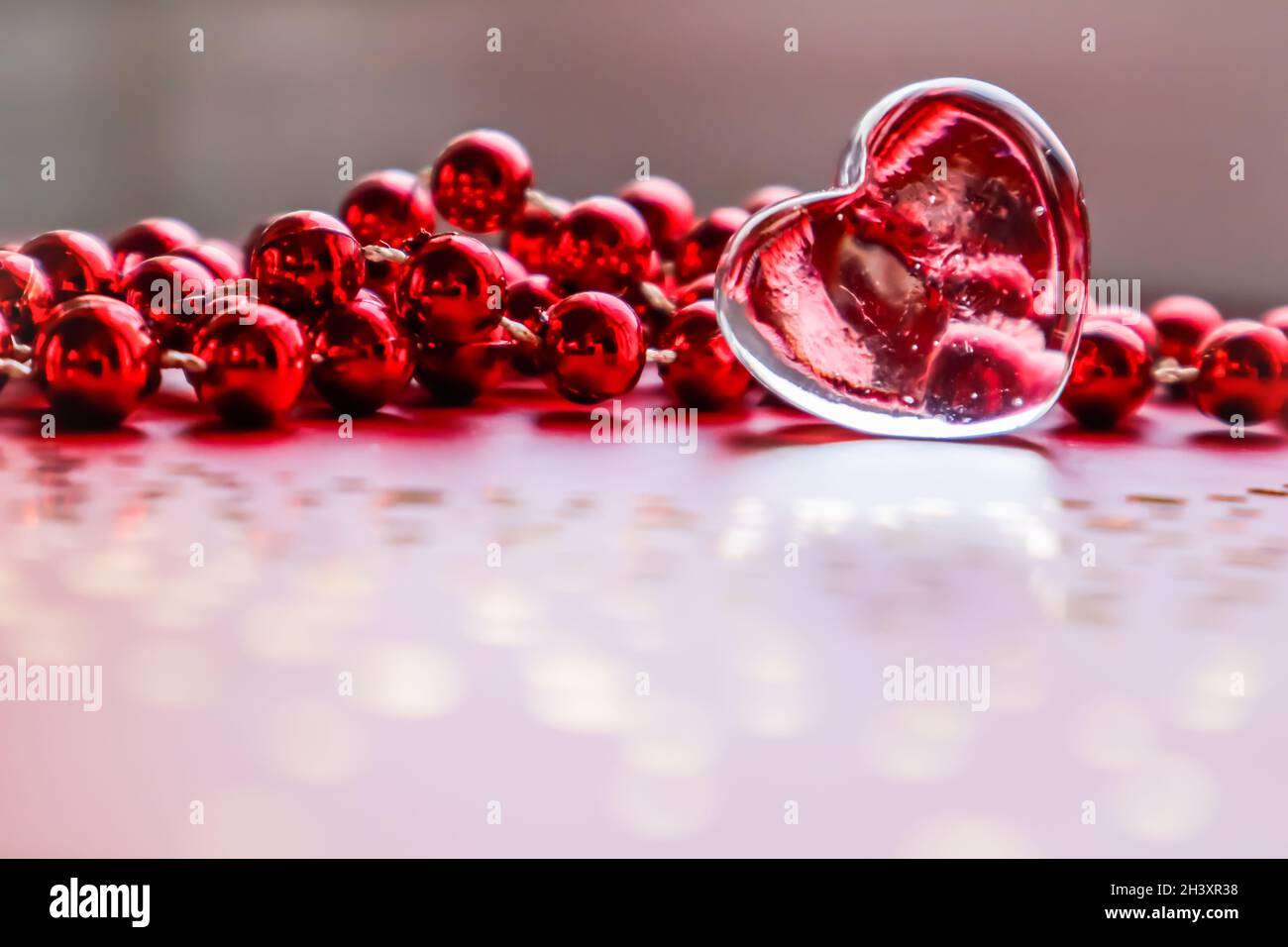 Coeur transparent brillant et perles rouges. Saint-valentin parfait fond de carte de vœux. Banque D'Images