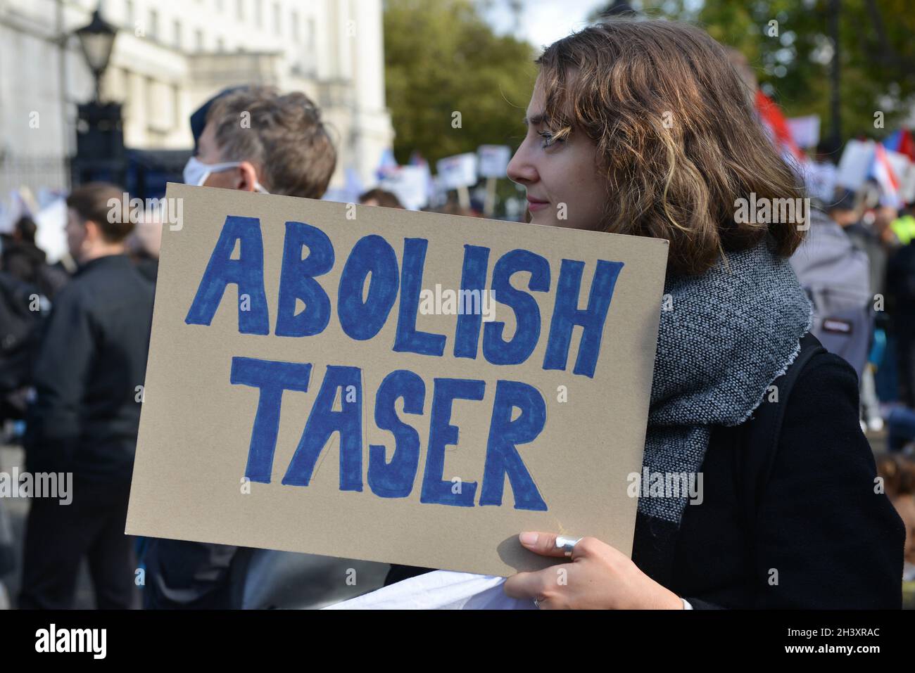 Un manifestant tient un écriteau « abolir le Taser » pendant la manifestation à l'extérieur de Downing Street. Banque D'Images
