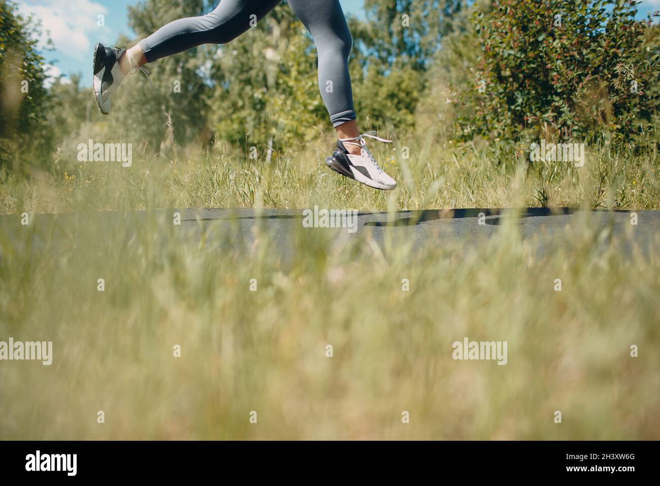 Femme coureur en chaussures de course à pied gros plan de femme sportive volant jambes.Jogging féminin. Banque D'Images