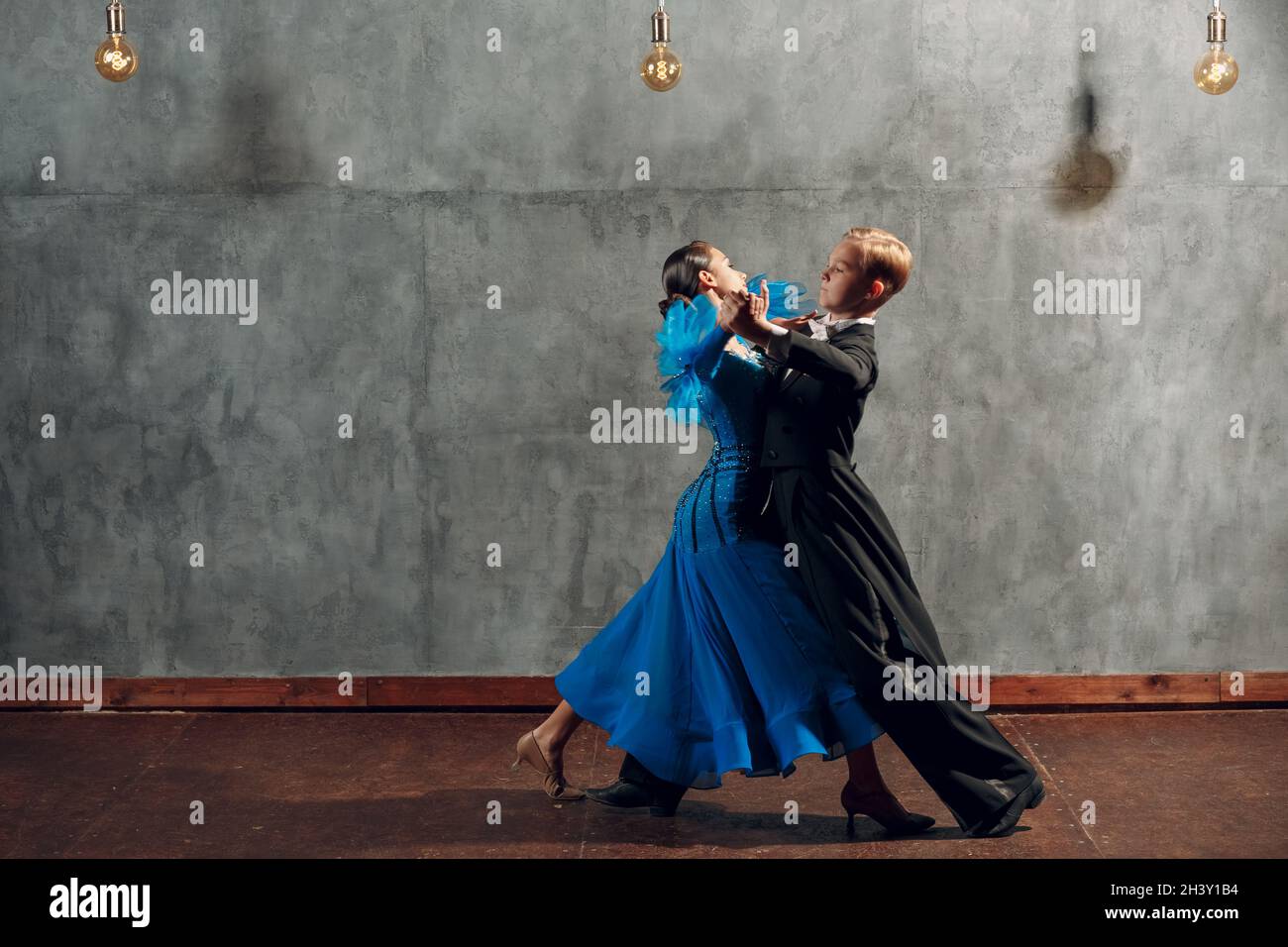 Un jeune couple danse la valse lente dans la salle de bal. Banque D'Images