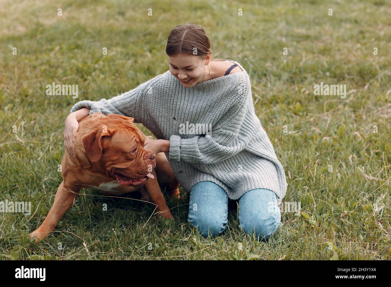 Dogue de Bordeaux ou Mastiff français avec une jeune femme au parc extérieur Banque D'Images