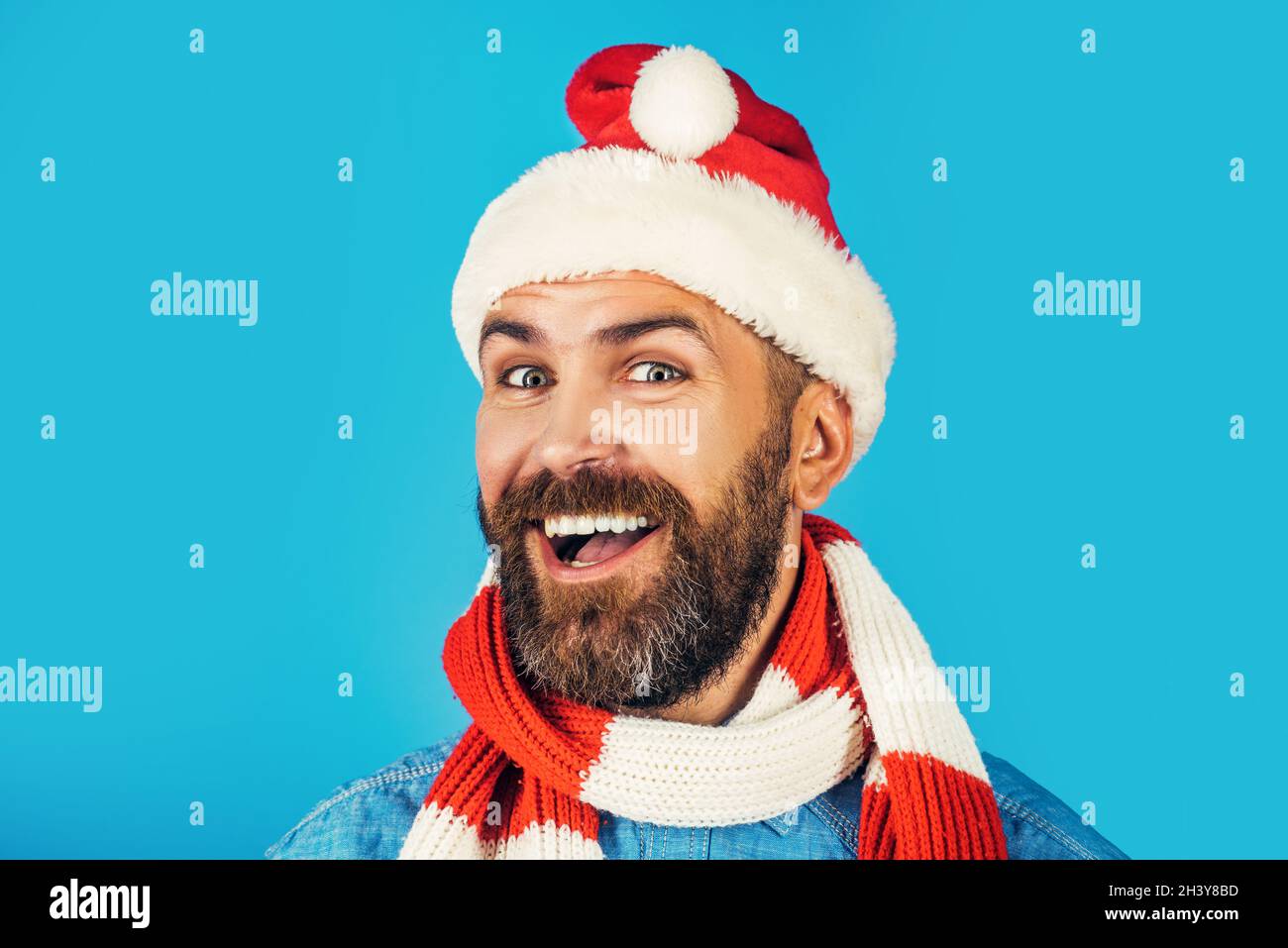 Noël homme souriant avec chapeau et écharpe de père noël sur fond  bleu.Nouvel an, Noël, fête des vacances d'hiver, espace copie.père noël  barbu Photo Stock - Alamy