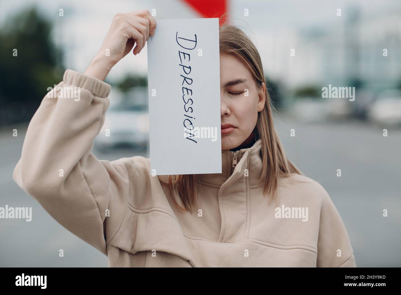 Femme tenant une feuille de papier blanc étiquetée dépression mot dans la main. Banque D'Images