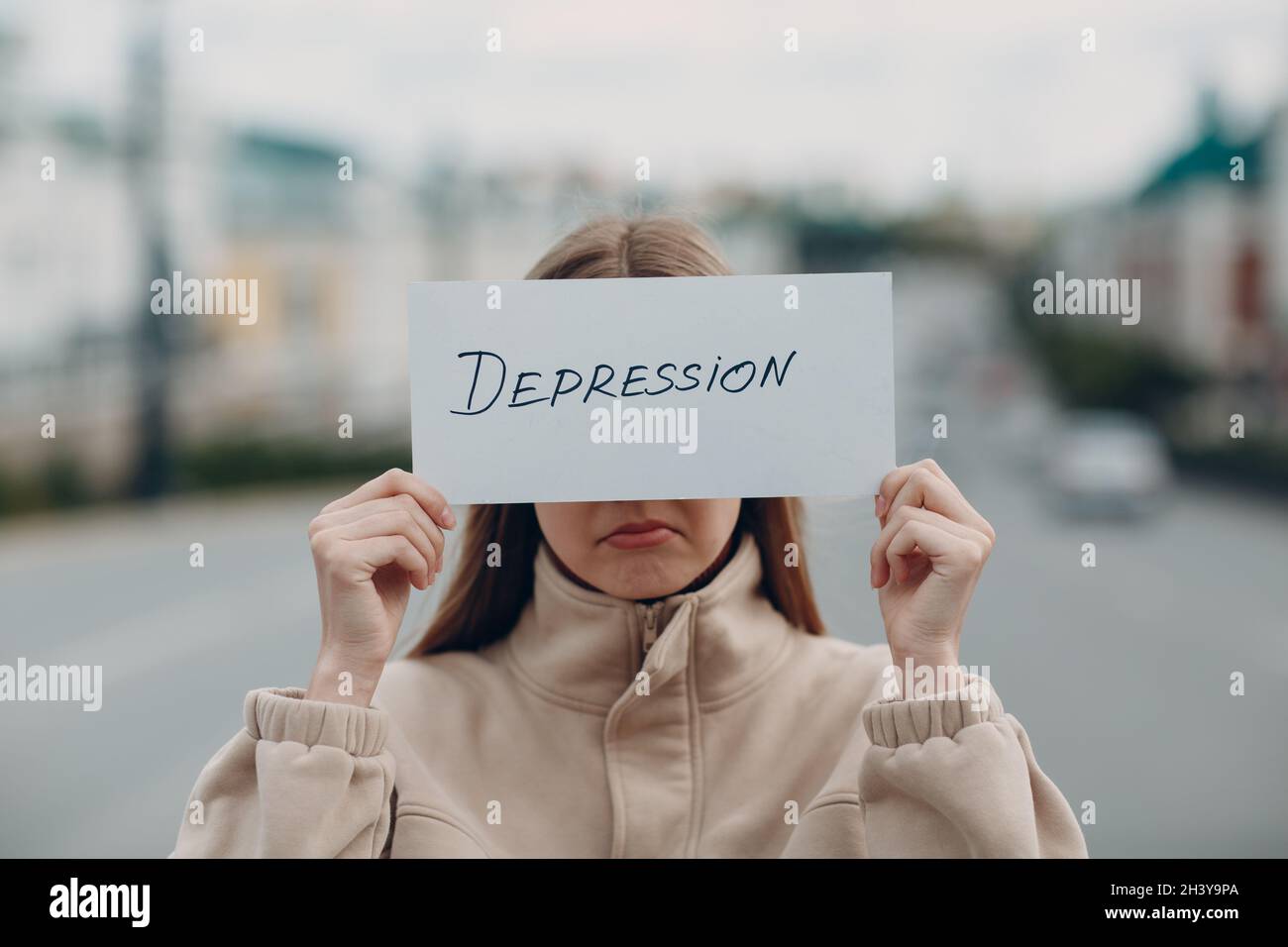 Triste femme tenant le papier blanc de feuille étiqueté de dépression dans la main. Banque D'Images