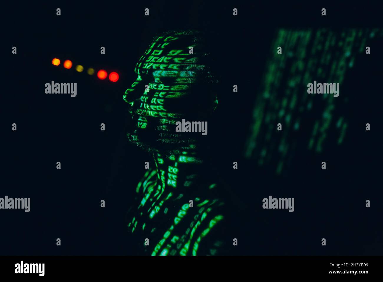 Jeune homme avec des lettres abstraites geen sur son visage dans l'obscurité. Banque D'Images