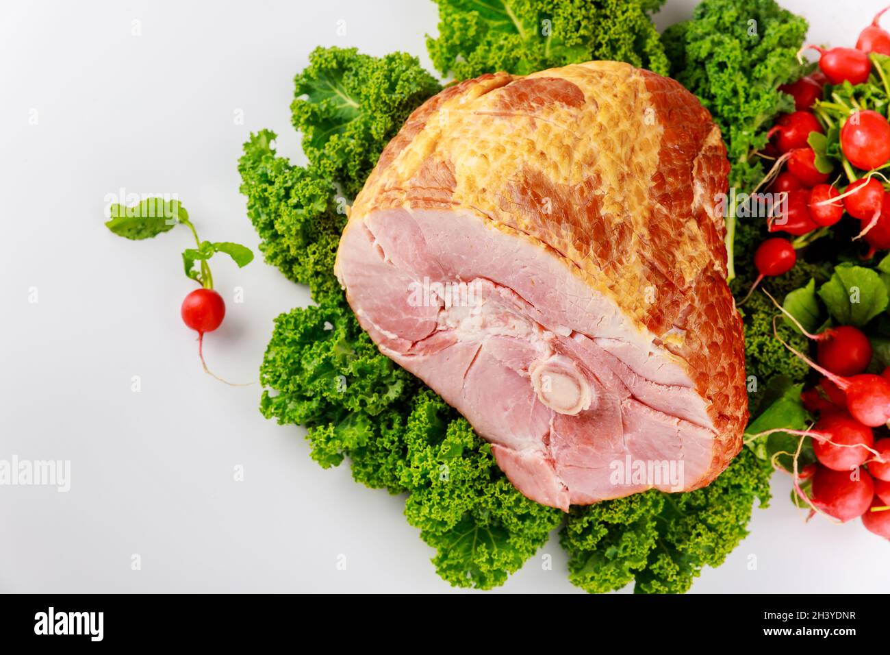 Jambon de porc fumé et précuit décoré de radis frais. Banque D'Images
