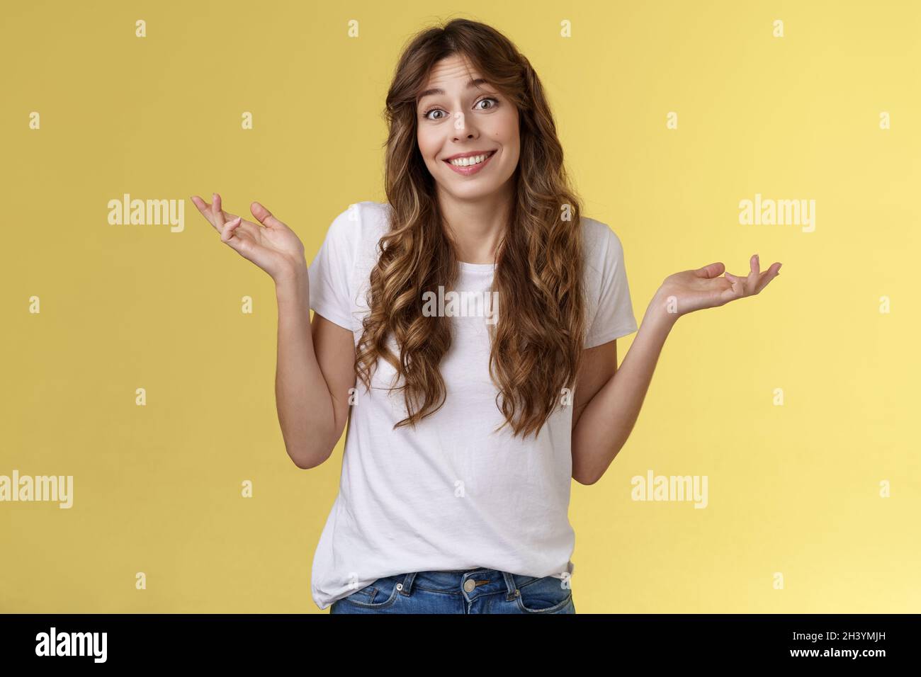 Qui se soucie de Amuse-toi bien.Insouciante indifférente jeune femme heureuse élève les mains sur le côté, sans rien d'ennuyé, apathique à t Banque D'Images