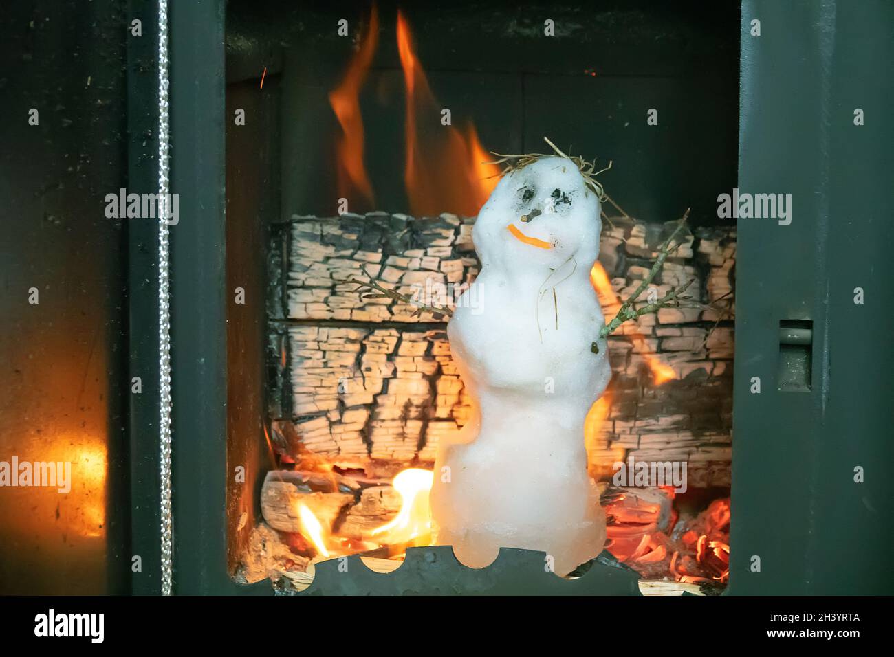 Le petit bonhomme de neige fond rapidement dans le poêle chaud Banque D'Images