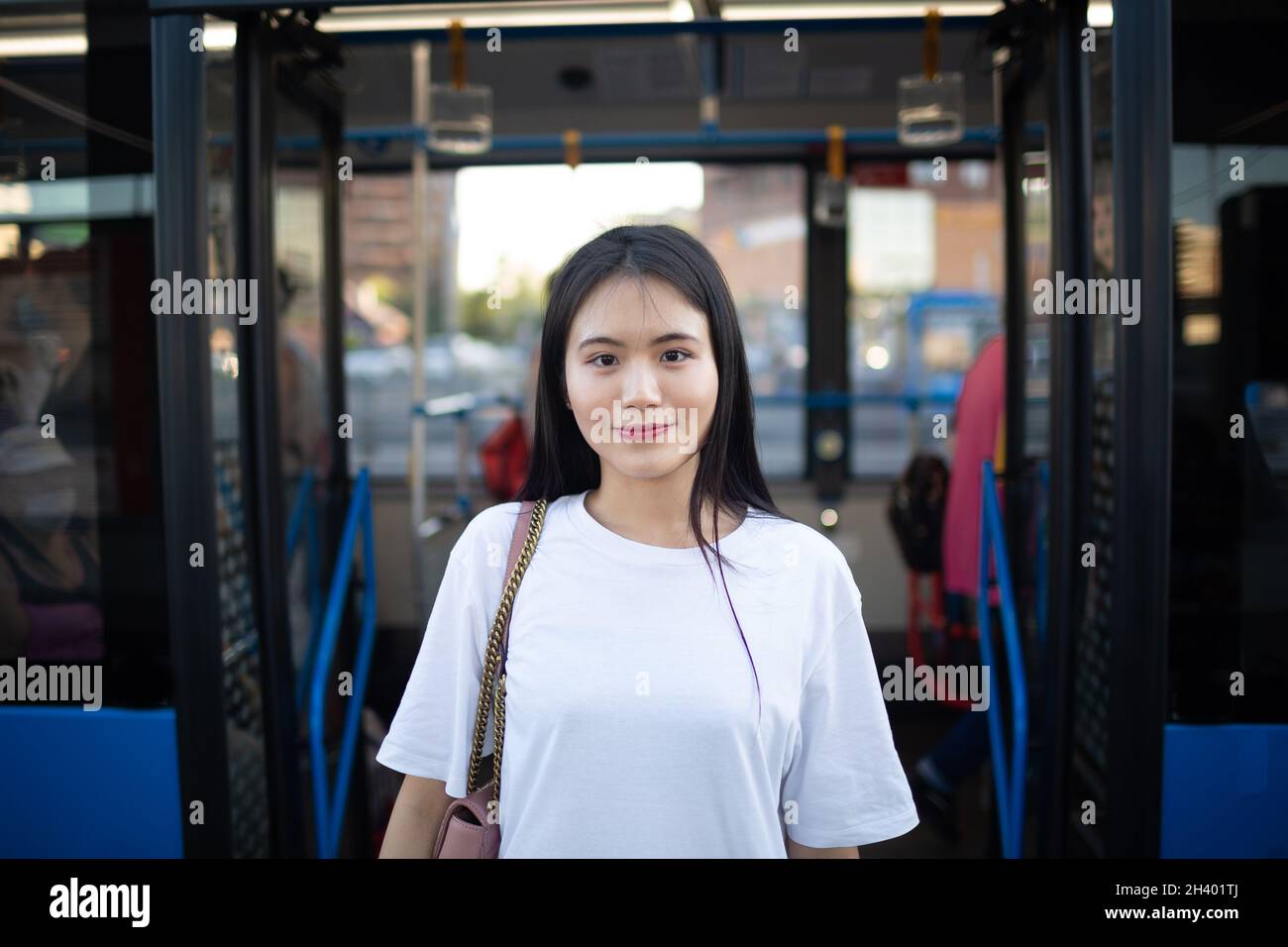 Une femme asiatique sort par les portes après avoir pris le bus ou le tramway en transports en commun. Banque D'Images