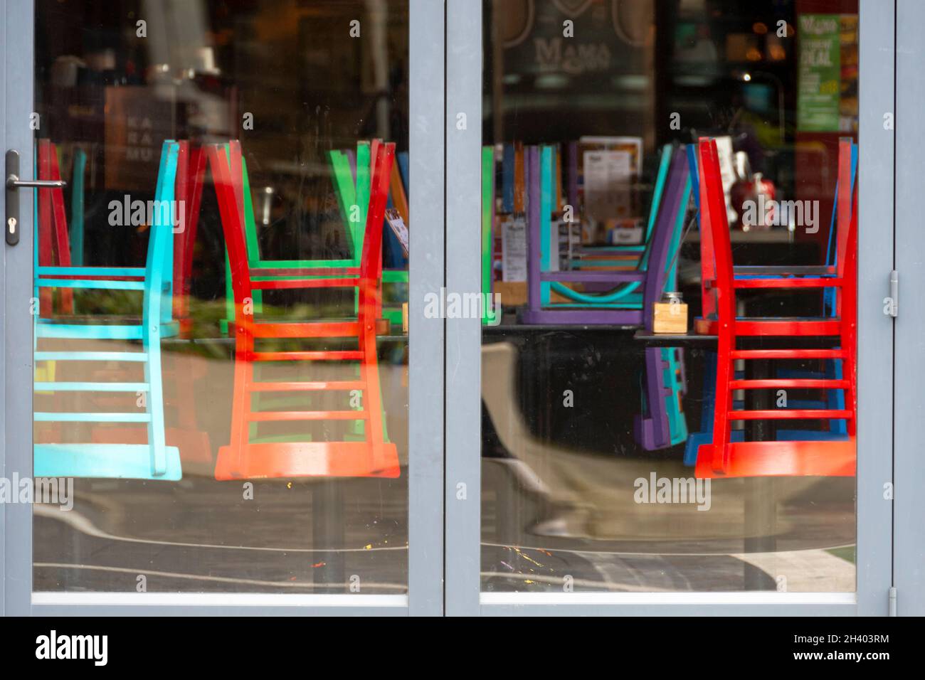 Chaises colorées sur les tables dans un café à Wellington, Île du Nord, Nouvelle-Zélande Banque D'Images