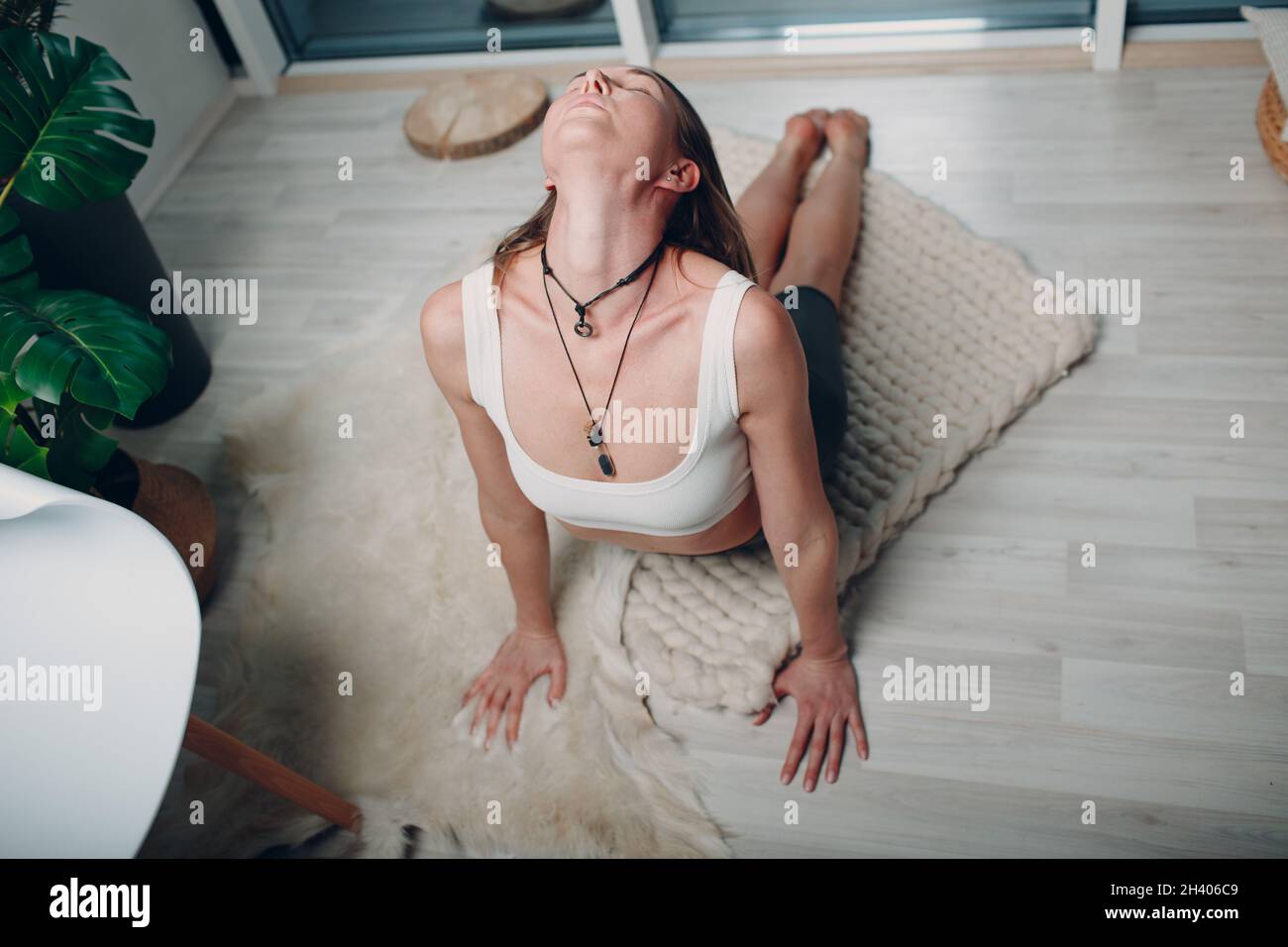 Femme adulte mature faisant du yoga dans le salon à la maison Banque D'Images