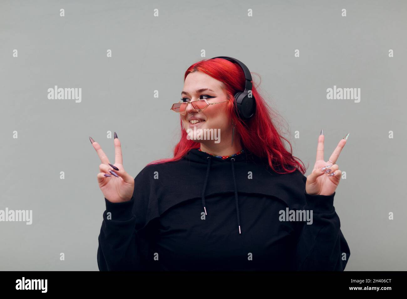 Femme européenne de taille plus.Jeune fille positive de corps rouge à cheveux rose Banque D'Images