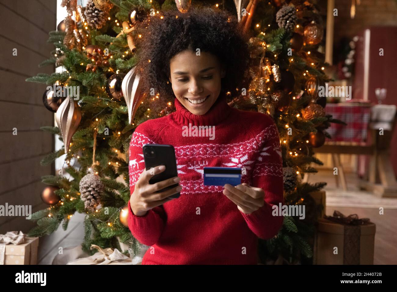 Bonne femme biracial boutique en ligne avec smartphone Banque D'Images