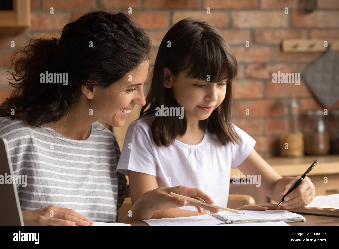 Bonne maman aidant la fille de l'école primaire à faire ses devoirs Banque D'Images
