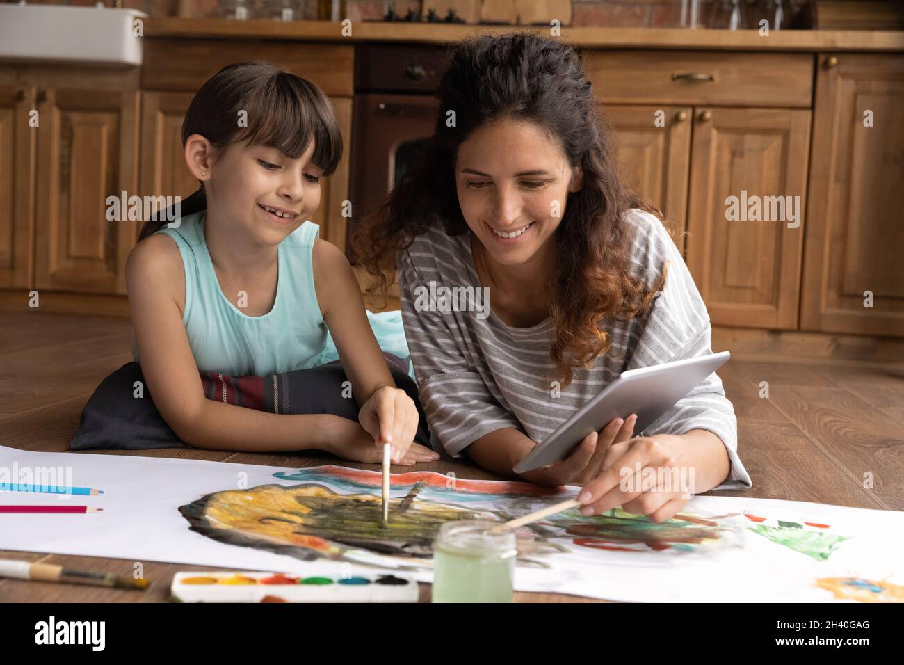 Bonne maman hispanique et fille s'est engagée dans la peinture de l'image Banque D'Images