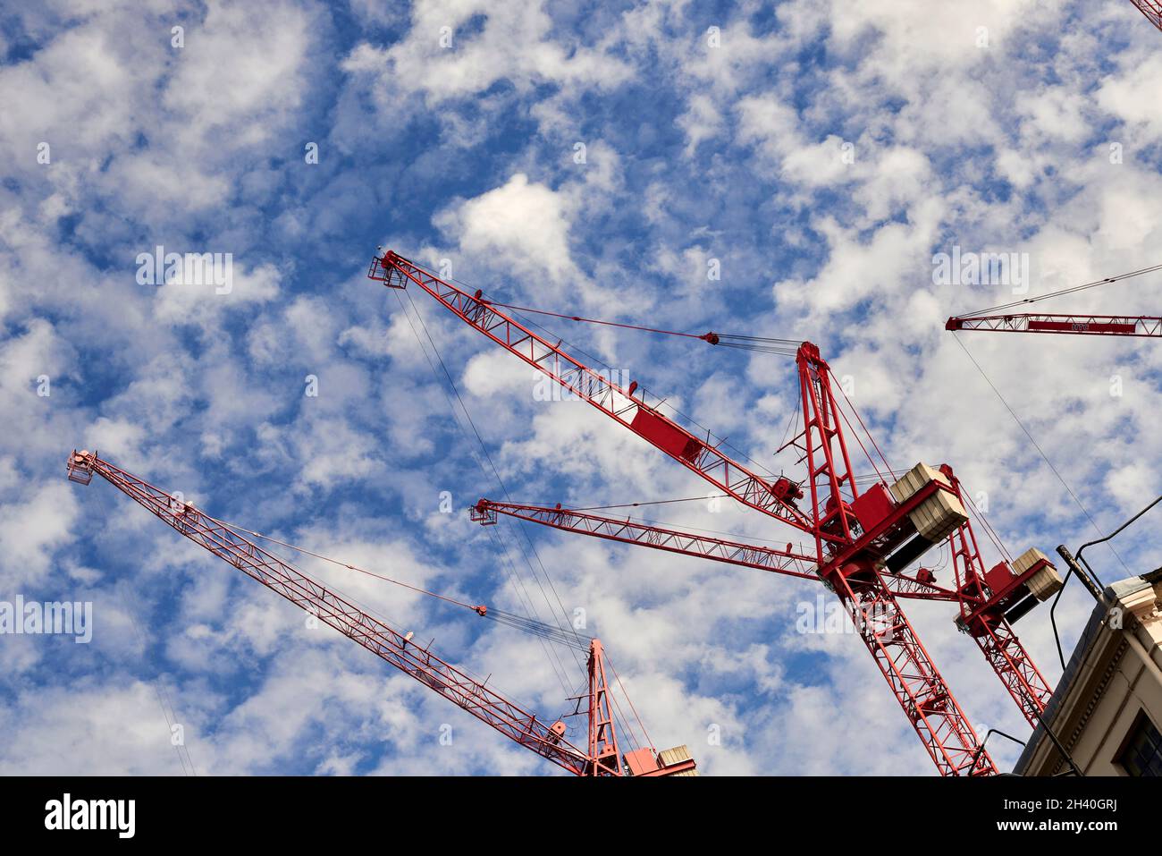 Grues rouges de construction sur ciel nuageux Banque D'Images