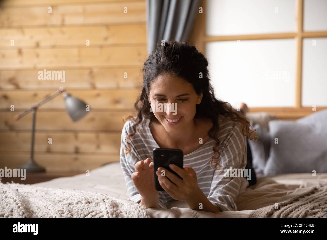 Une femme souriante lit un message avec de bonnes nouvelles Banque D'Images