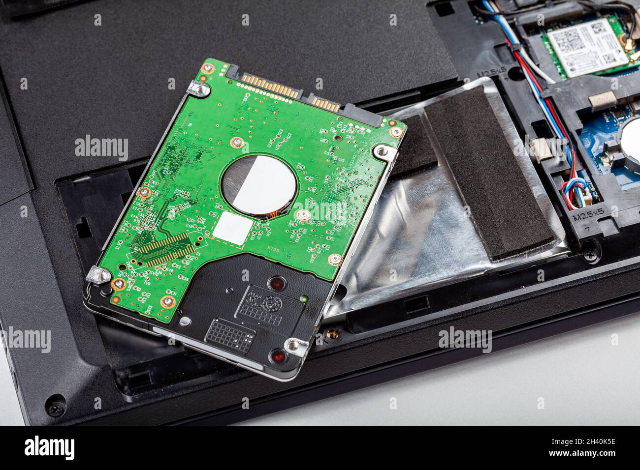 Un nouveau disque dur de 2.5 pouces, un disque dur posé sur un ordinateur portable ouvert moderne démonté, stockage de fichiers.Remplacement du disque dur, protection des données numériques Banque D'Images