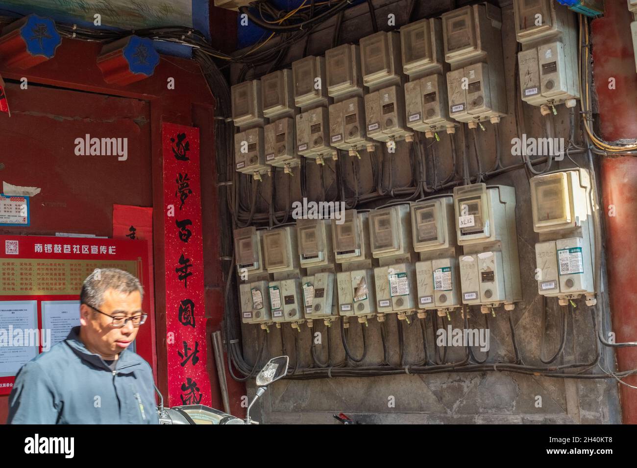 Un résident passe devant les compteurs électriques de chaque famille à l'entrée d'une cour dans le centre de Beijing, en Chine.31 octobre 2021 Banque D'Images
