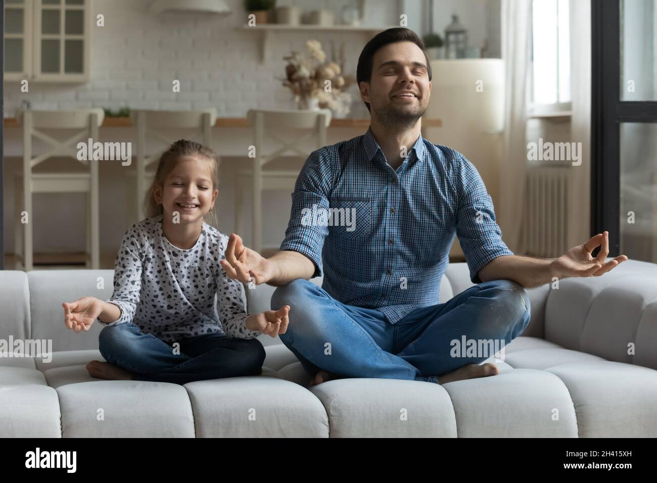Bonne petite fille et jeune père pratiquant le yoga. Banque D'Images