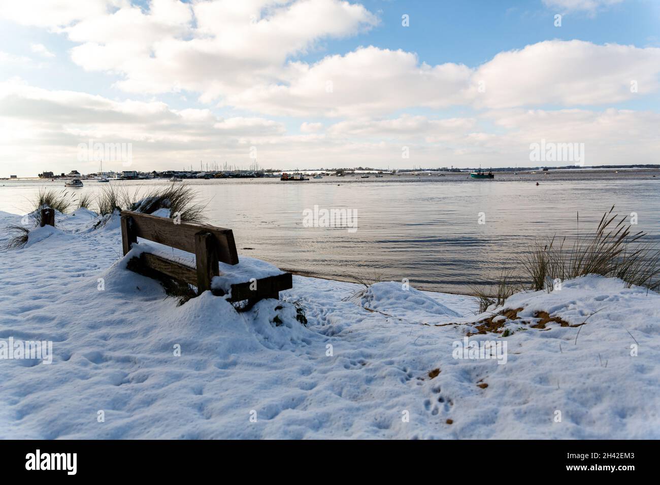 Un banc couvert de neige avec vue sur la plage et la rivière Deben au populaire quai Bawdsey sur la côte du Suffolk Banque D'Images