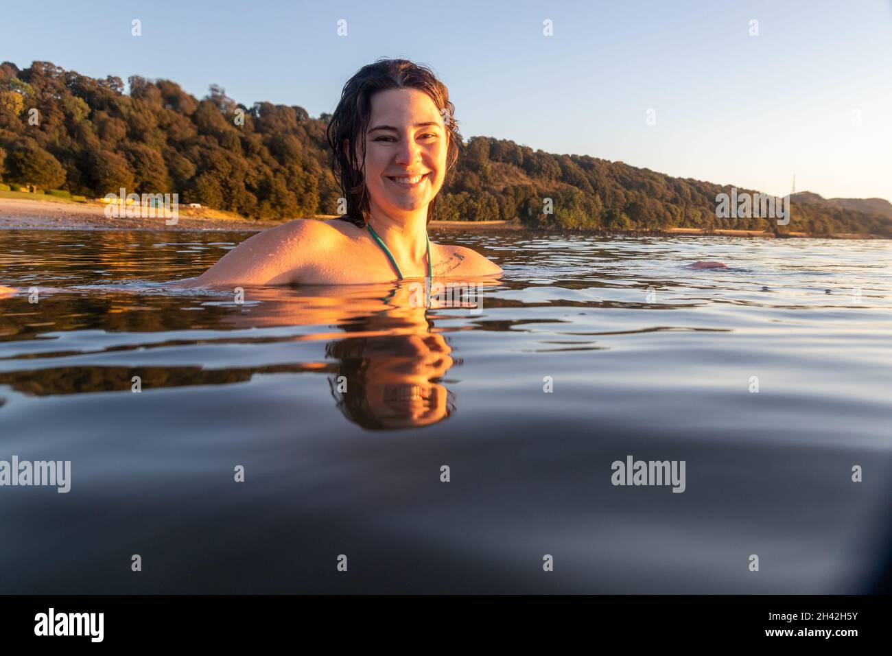Une jeune écossaise nageant d'eau froide au lever du soleil dans la mer à Aberdour en octobre, à Fife, en Écosse Banque D'Images