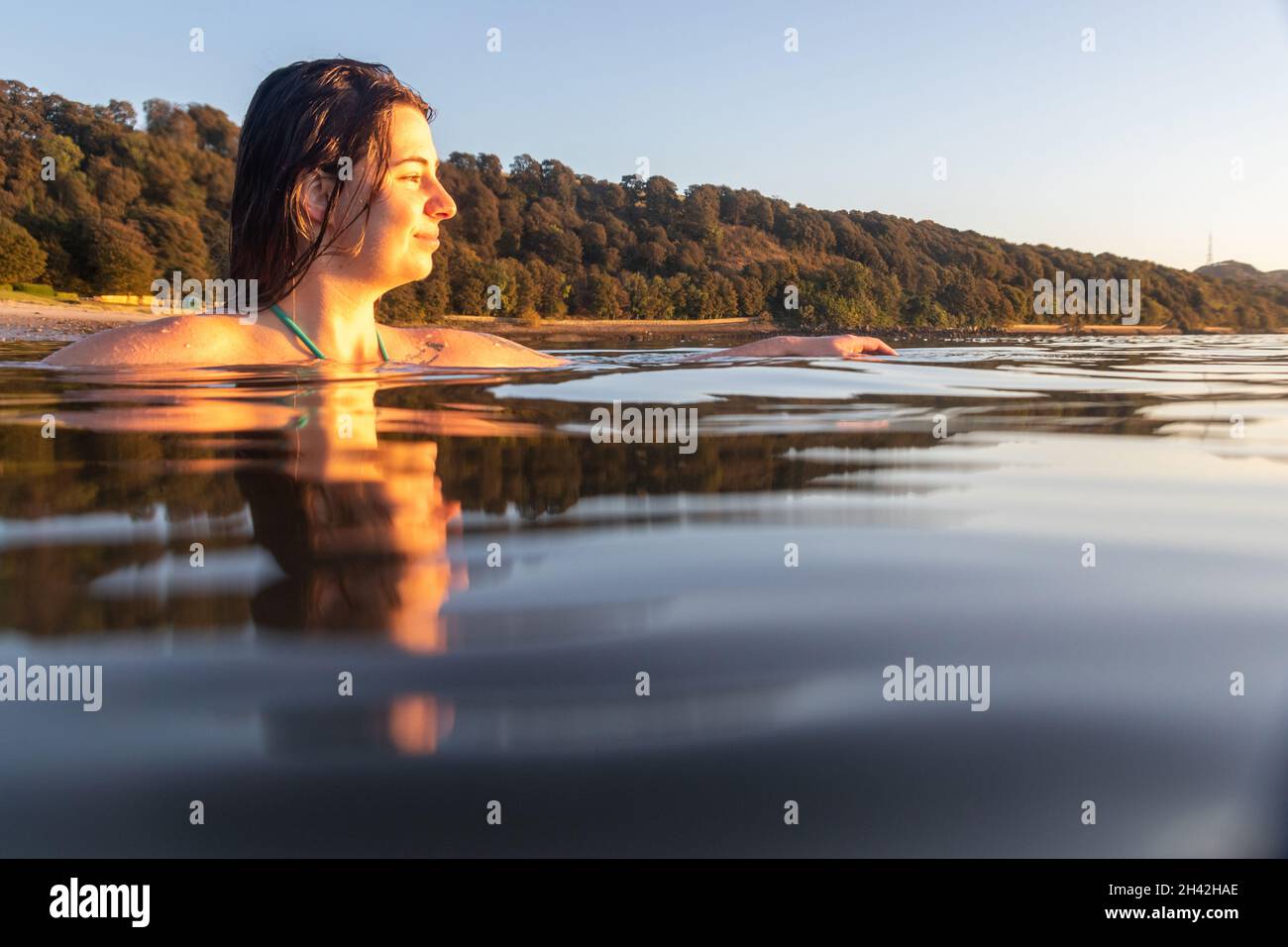 Une jeune écossaise nageant d'eau froide au lever du soleil dans la mer à Aberdour en octobre, à Fife, en Écosse Banque D'Images