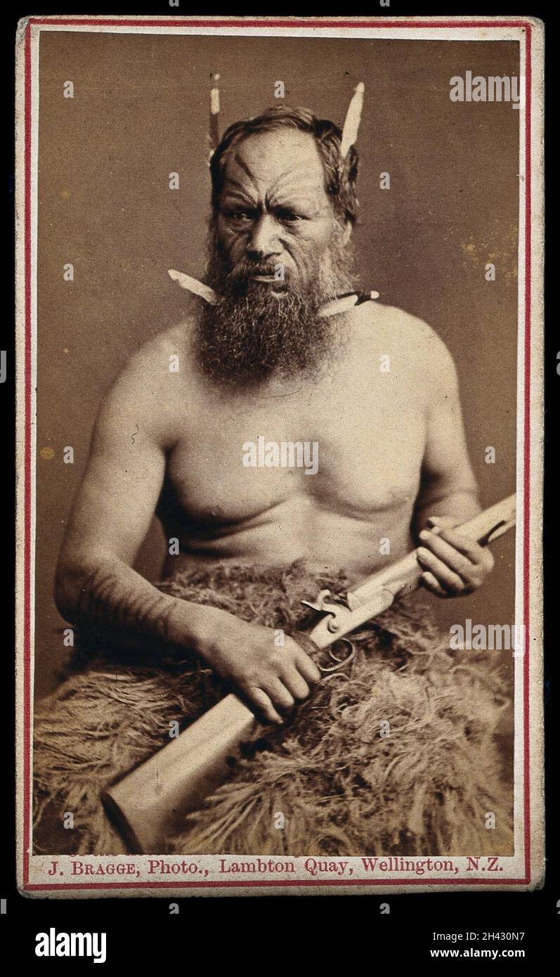 Homme maori au visage tattoembout, tenant un fusil.Photographie de J. Bragge, 188-. Banque D'Images