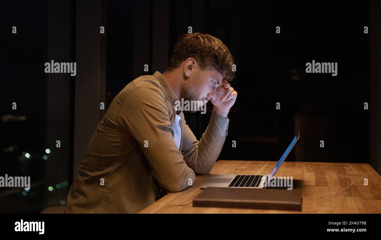 Angoissés stressé jeune homme d'affaires travaillant sur ordinateur. Banque D'Images