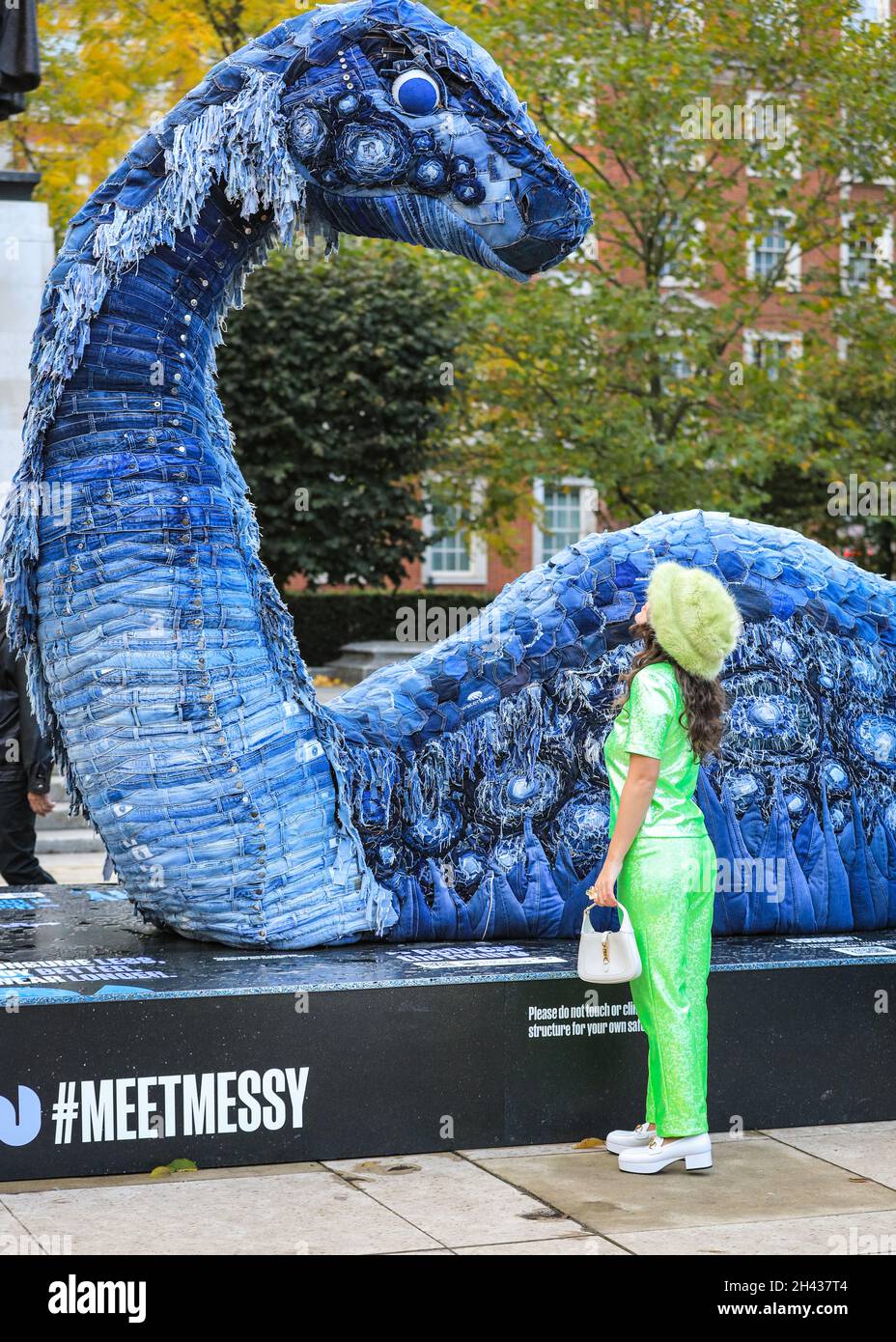 Grosvenor Square, Londres, Royaume-Uni.31 octobre 2021.Les gens regardent et posent avec désordre le monstre NESS de COP.Le désordre est entièrement fait à partir de jeans recyclés et d'autres matériaux durables, et sera sur Grosvenor Square jusqu'à novembre 12.La sculpture est une collaboration entre l'artiste Billie Achilleos, plate-forme de streaming WaterBear et MUD Jeans, une marque circulaire de denim.Credit: Imagetraceur/Alamy Live News Banque D'Images