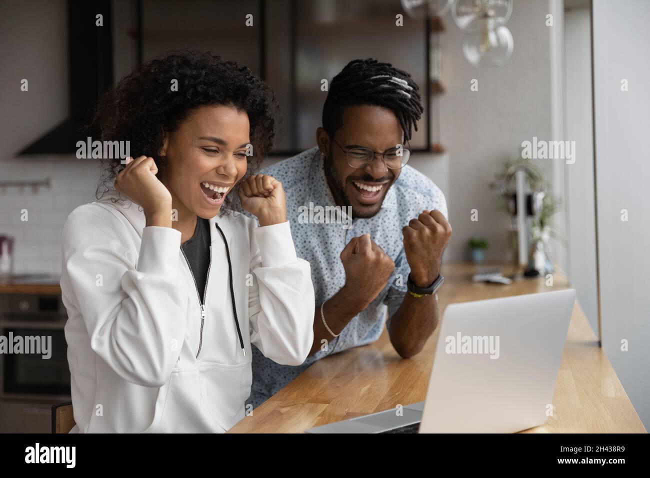 Joyeux rire jeune couple africain célébrant le succès d'Internet. Banque D'Images