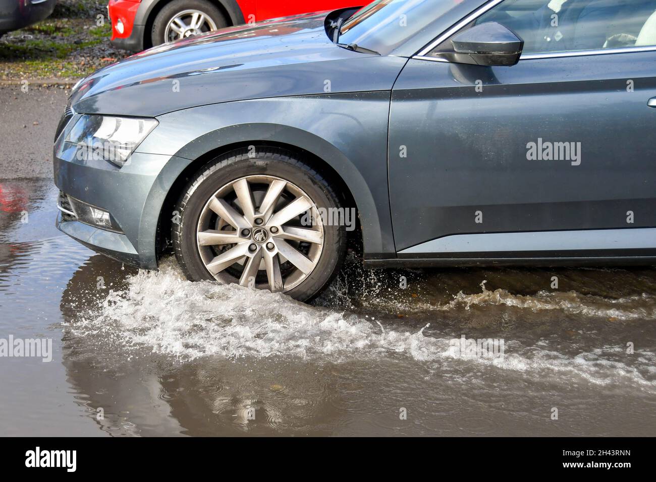 Kidderminister, Angleterre - octobre 2021 : éclaboussures d'eau lorsqu'une voiture traverse une grande flaque d'eau après une forte pluie d'une tempête Banque D'Images