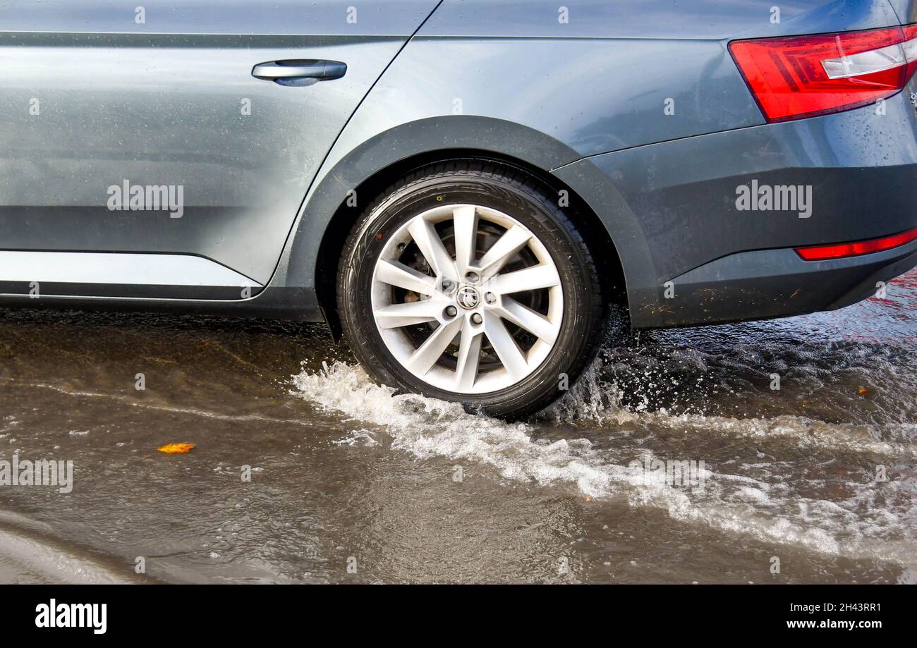 Kidderminister, Angleterre - octobre 2021 : éclaboussures d'eau lorsqu'une voiture traverse une grande flaque d'eau après une forte pluie d'une tempête Banque D'Images