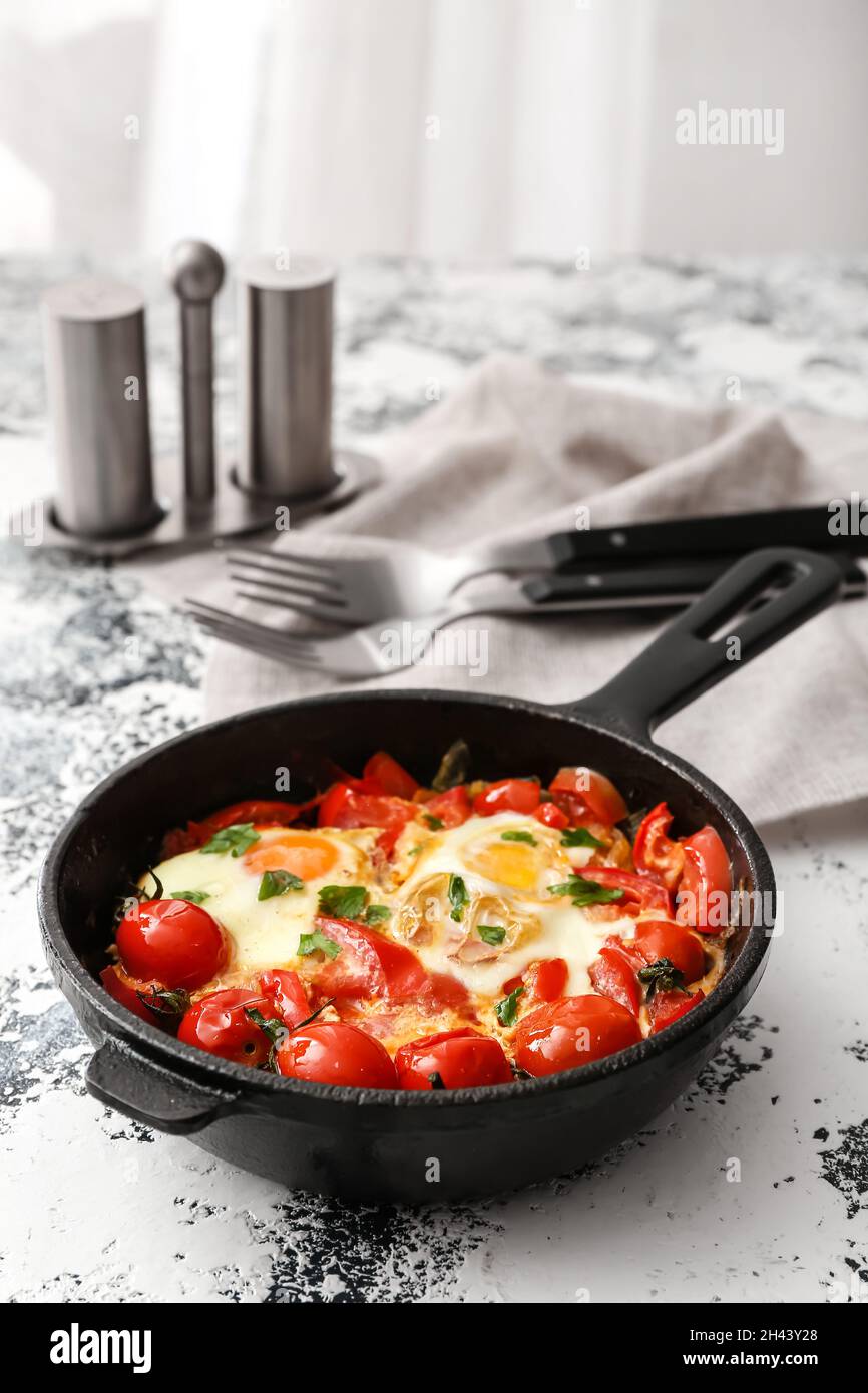 Poêle avec Shakshouka savoureux sur table Banque D'Images