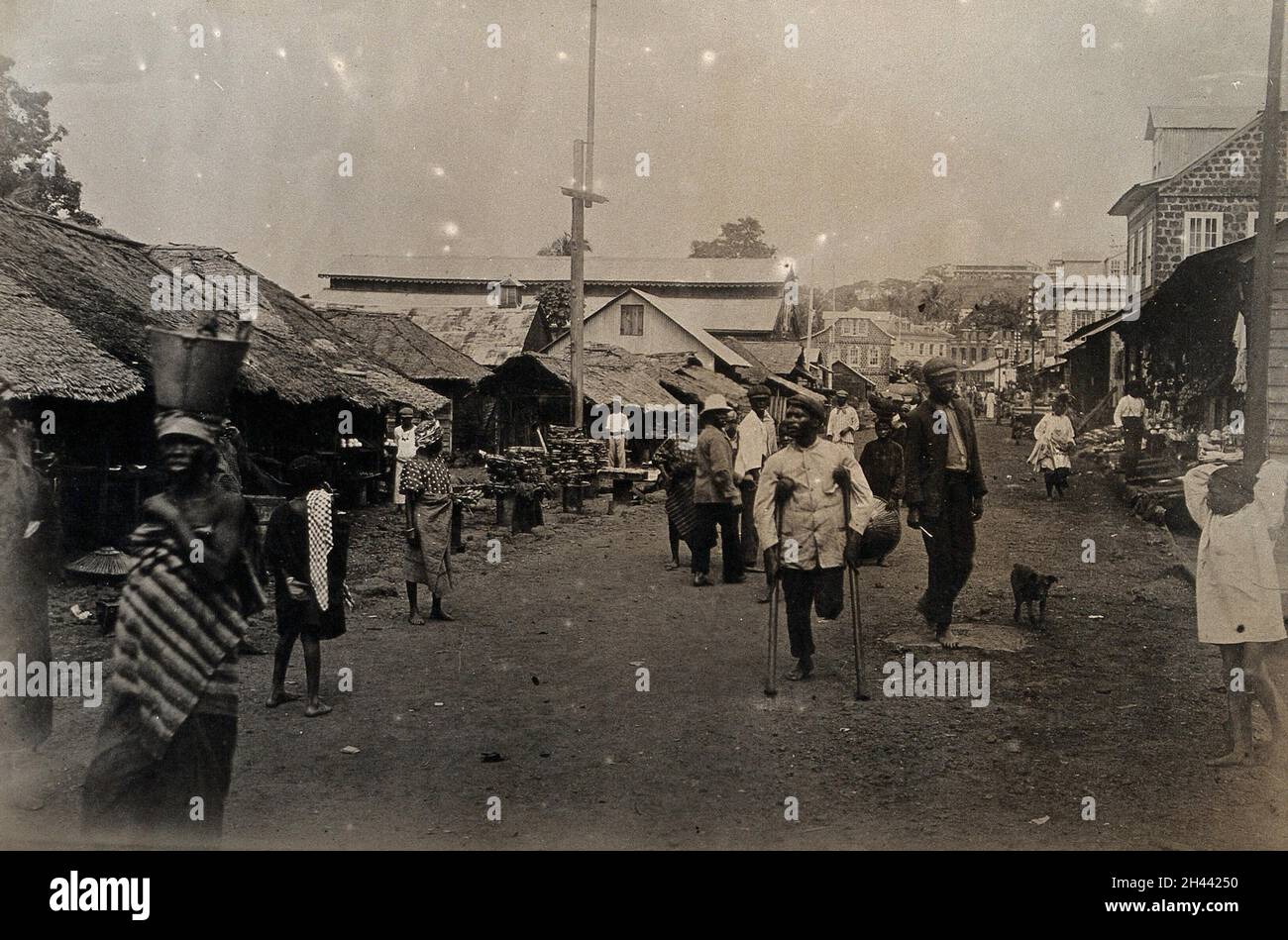 Freetown, Sierra Leone: Les habitants de la région, y compris un amputé sur des béquilles, sont montrés en marchant le long d'une des rues principales.Photographie, 1910/1920. Banque D'Images