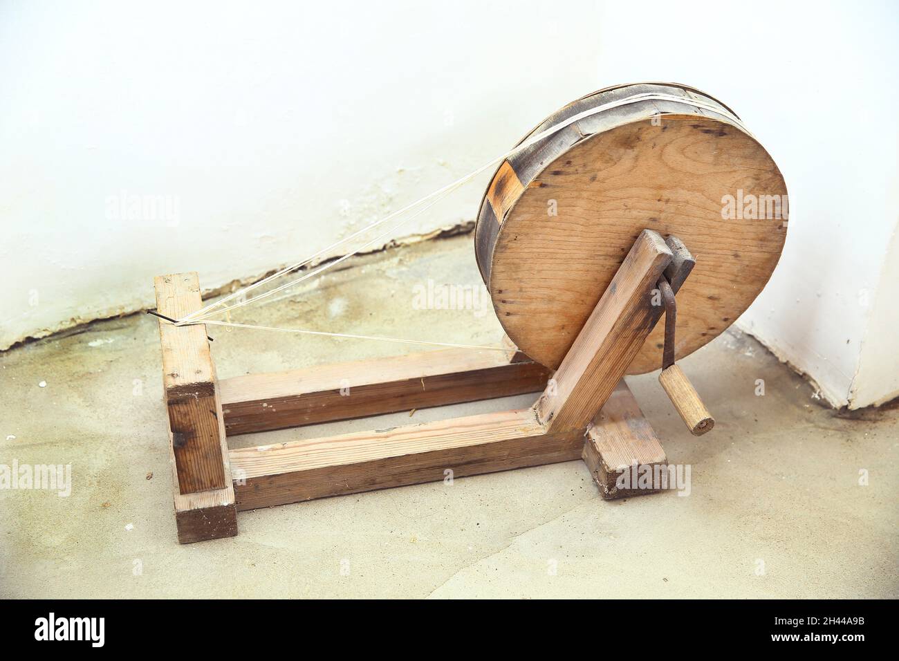 Un ancien outil rond en bois pour la fabrication de fils de laine .  Fabrication de fil de laine de mouton par roue de rotation traditionnelle .  Filature manuelle de laine à