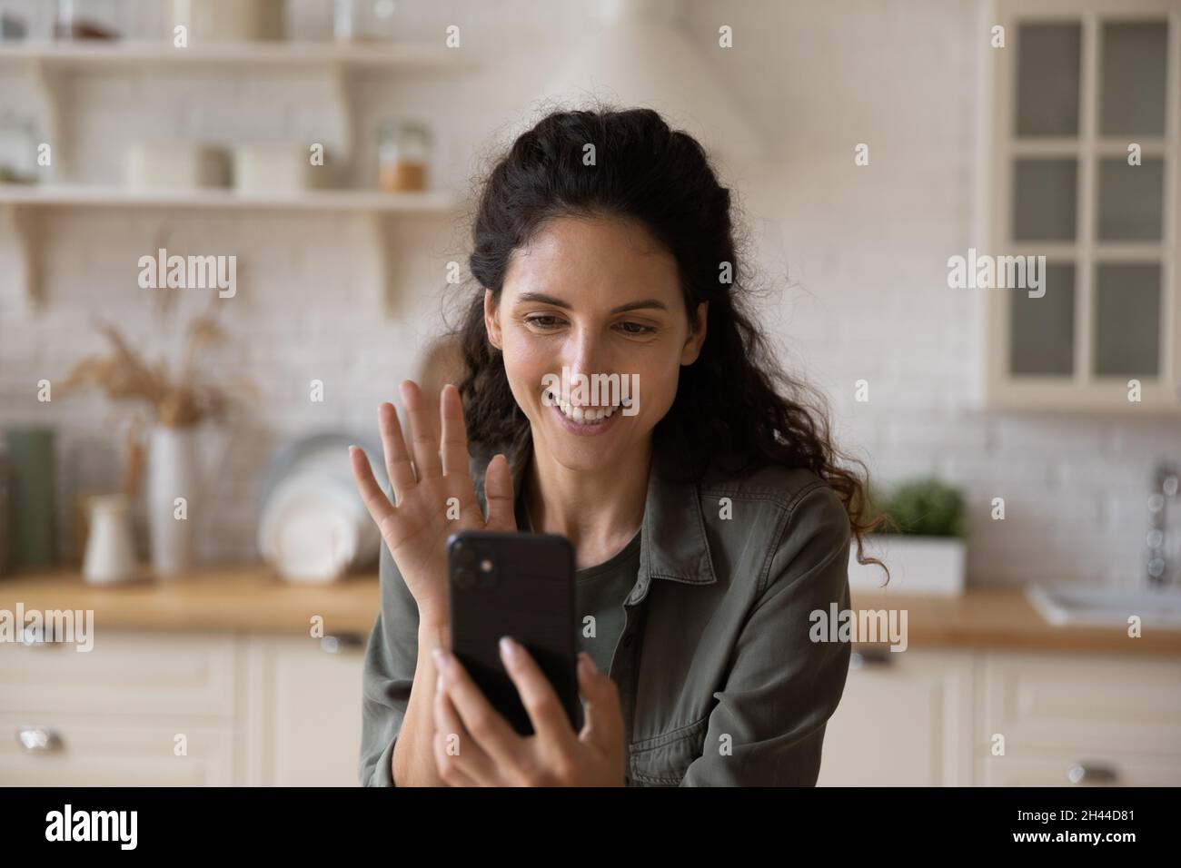 Femme hispanique attrayante faire appel de vidéoconférence utiliser le téléphone portable Banque D'Images