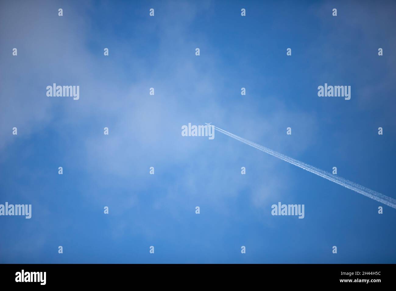 sentier de condensation d'un avion dans le ciel bleu, nuages Banque D'Images