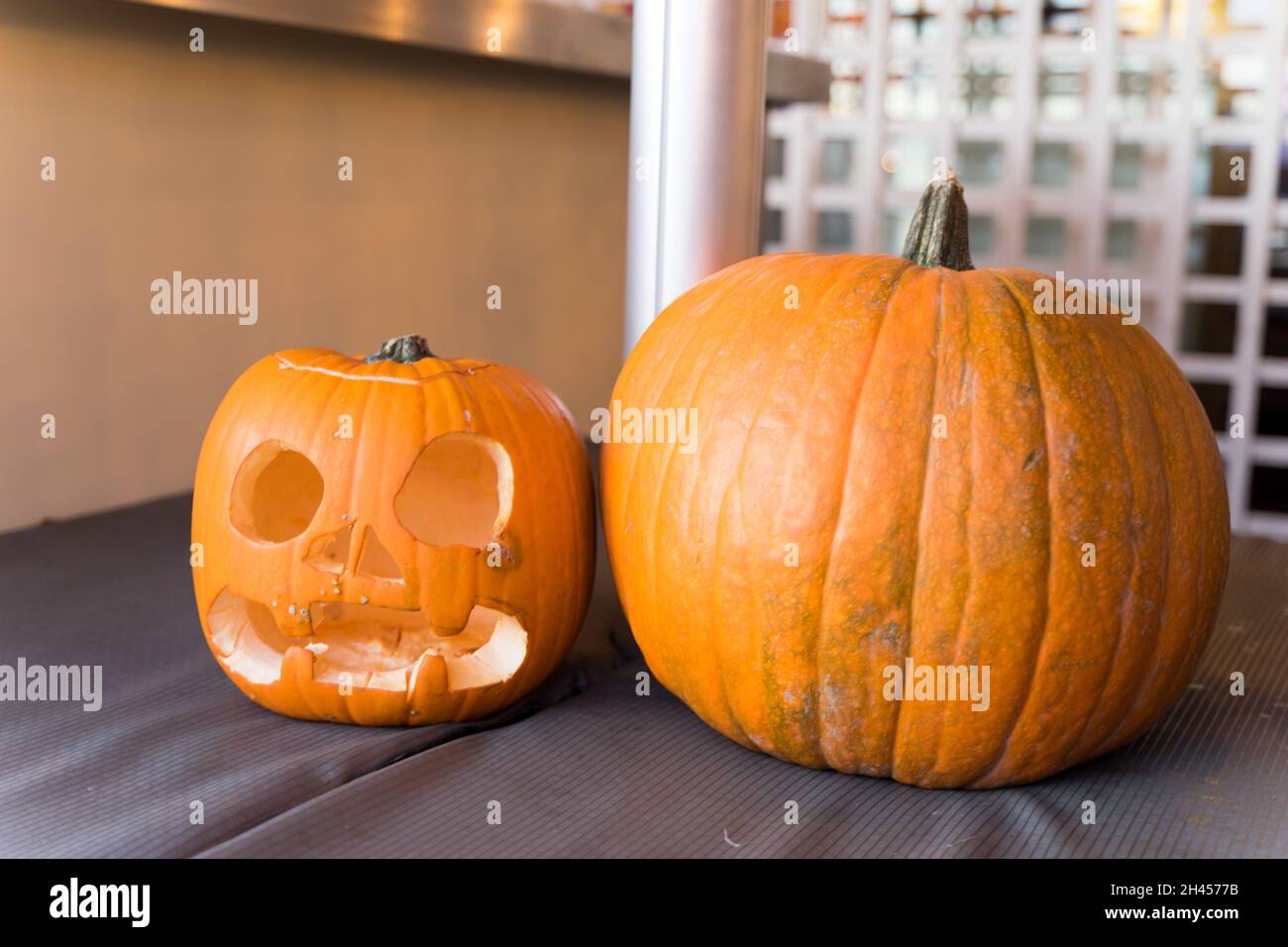 La citrouille d'Halloween sculptée s'assoit à côté de la plus grande citrouille entière à la nuit d'Halloween Londres Angleterre Royaume-Uni Banque D'Images