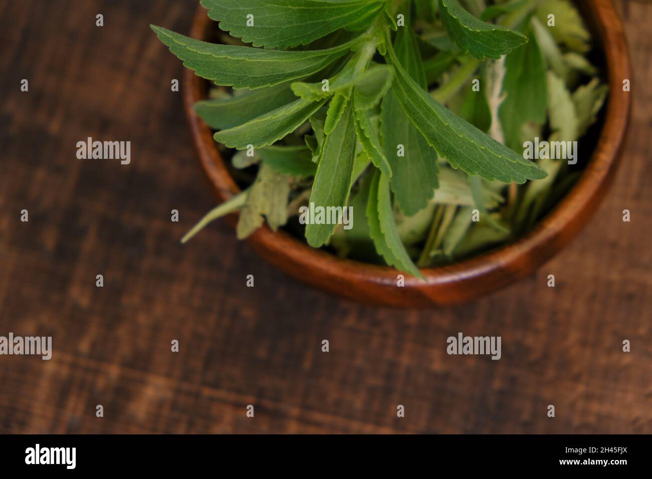 Stevia rebaudiana.Stevia sec et frais dans une tasse en bois sur une table en bois Banque D'Images