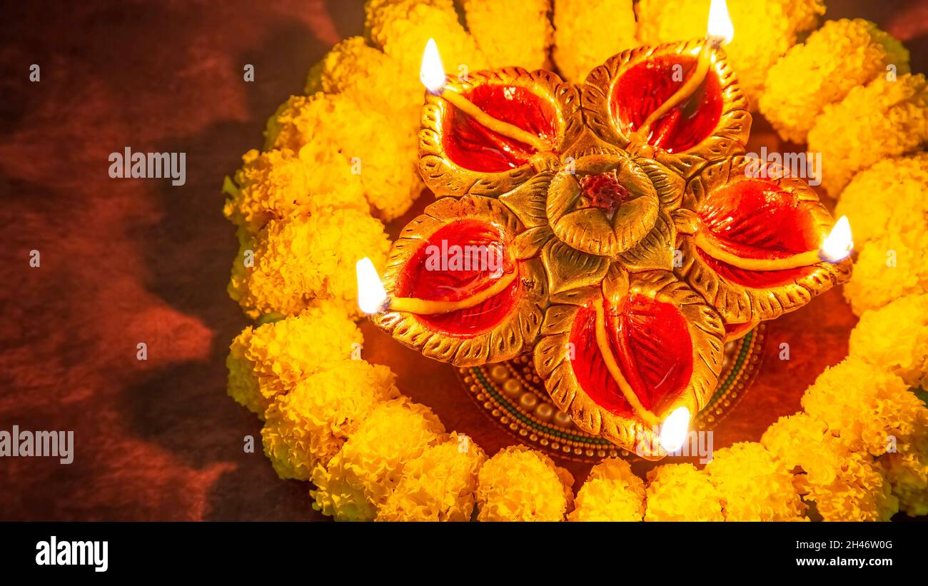 Arrière-plan Diwali avec lampes en argile Diya et fleurs marigold avec espace de copie Banque D'Images