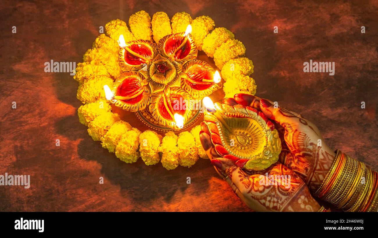 Femme éclairant des lampes en argile Diya pour la décoration du festival Diwali Banque D'Images