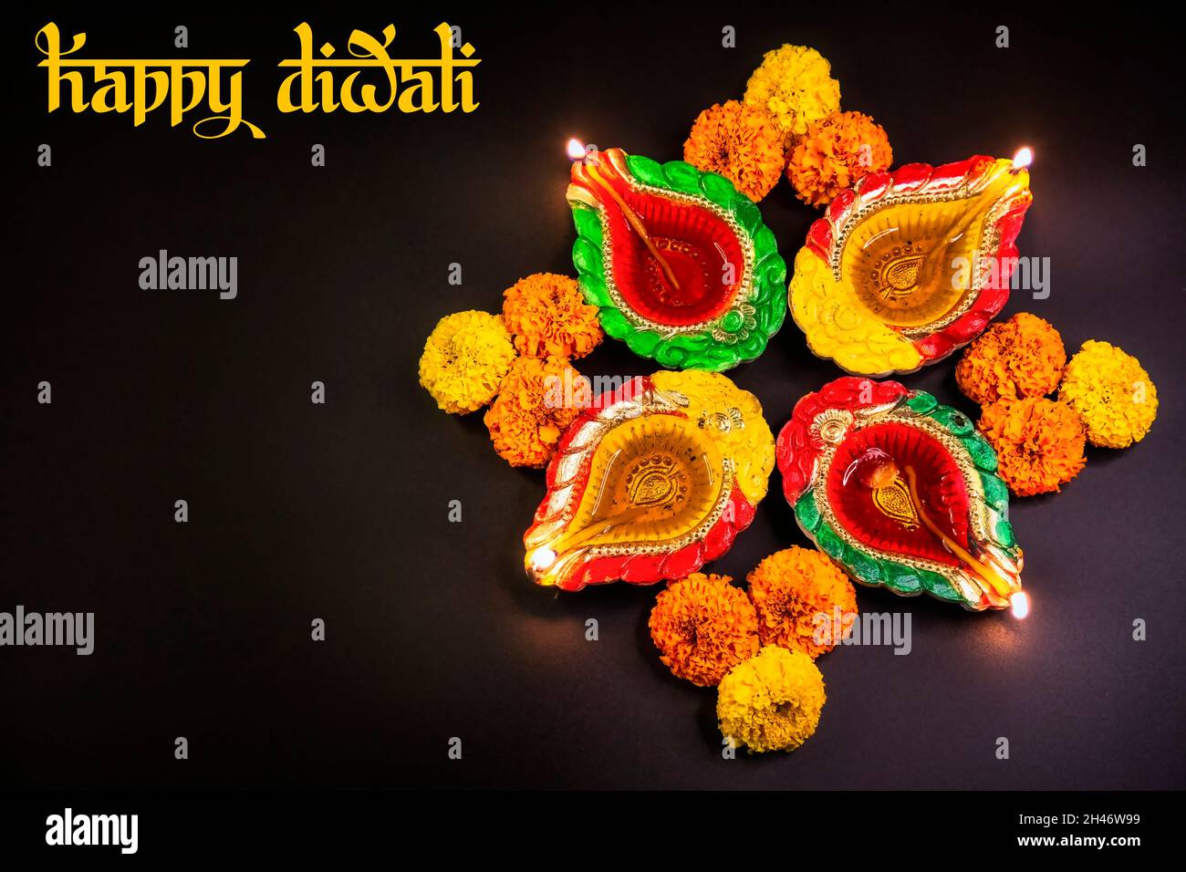 Diwali traditionnel argile lampes Diya décorées avec des fleurs marigold dans un fond sombre Banque D'Images