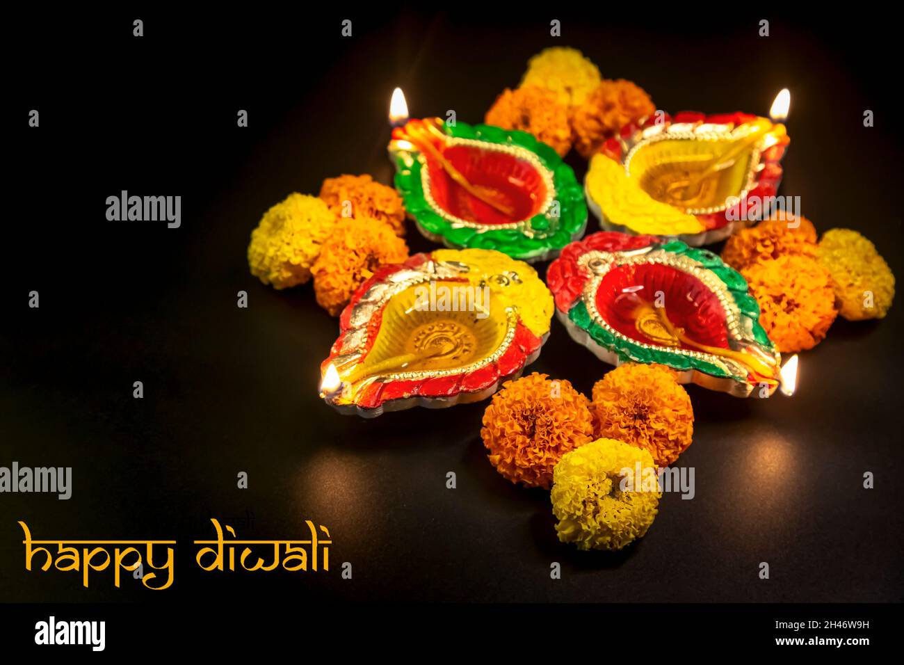 Diwali traditionnel argile lampes Diya décorées avec des fleurs marigold dans un fond sombre Banque D'Images