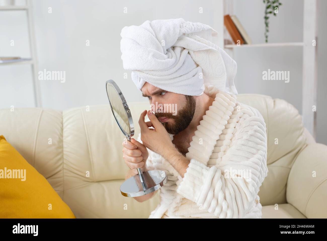 Homme barbu vérifiant sa peau du visage. Spa, soins du corps et de la peau pour homme concept. Banque D'Images