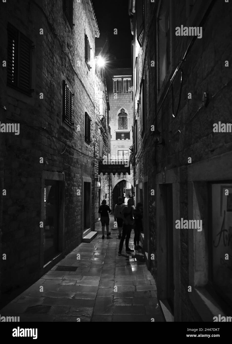 SPLIT, CROATIE - 25 septembre 2021: Une photo verticale en niveaux de gris des personnes dans les rues de Split en Croatie la nuit Banque D'Images