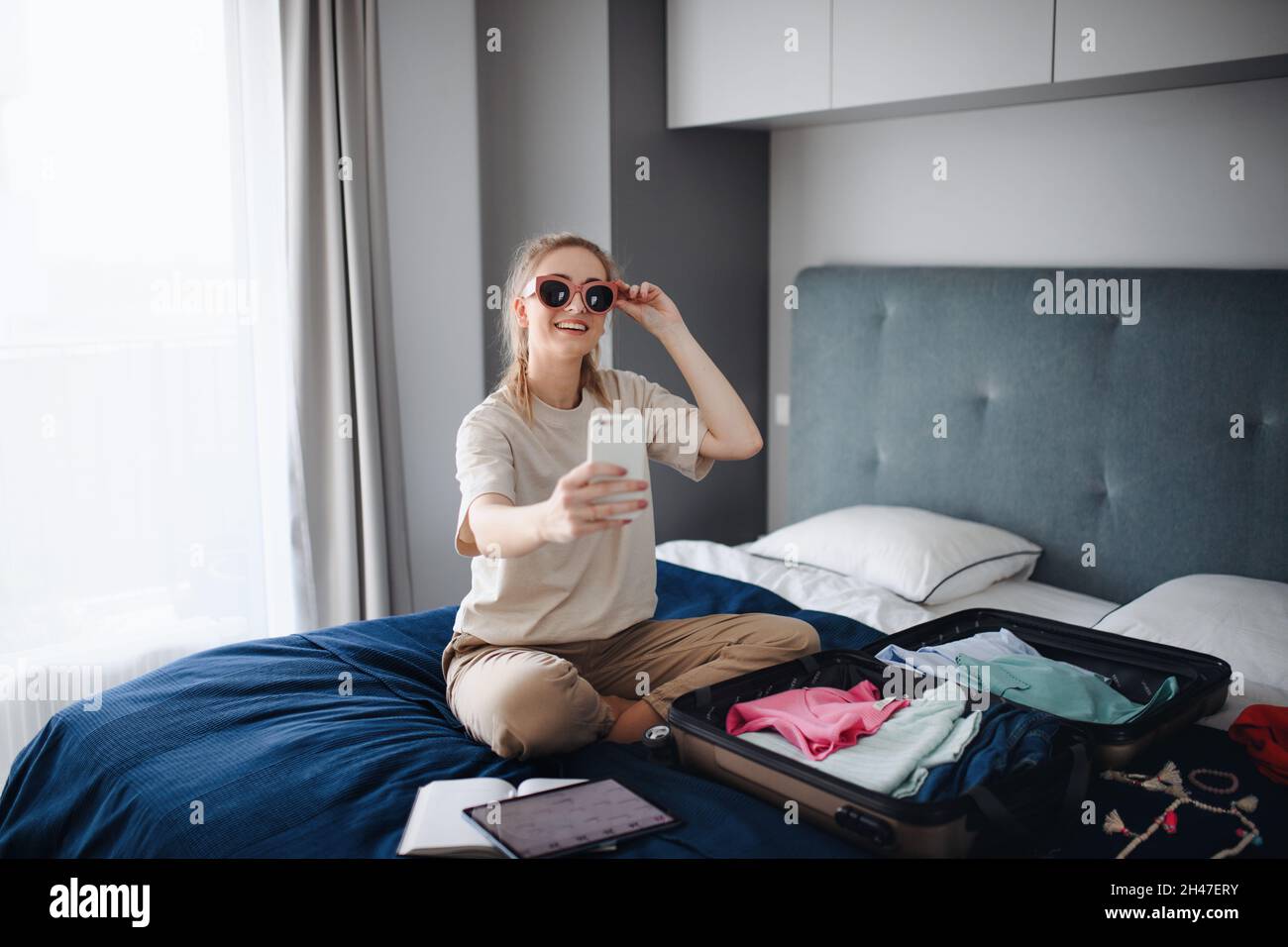 Portrait d'une jeune femme qui prend son selfie à l'intérieur à la maison, en planifiant des vacances. Banque D'Images