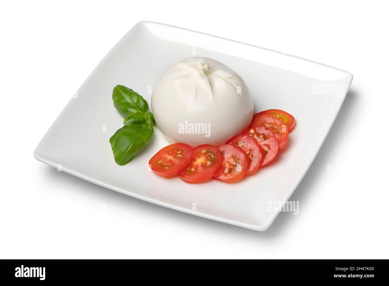 Plat avec du fromage burrata frais gros plan sur fond blanc avec des tranches de tomate et des feuilles de basilic Banque D'Images