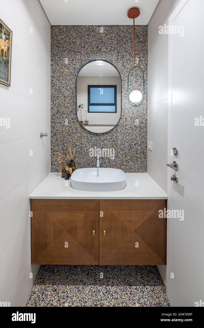 salle de toilettes, armoire en bois marron, évier ovale, luminaire