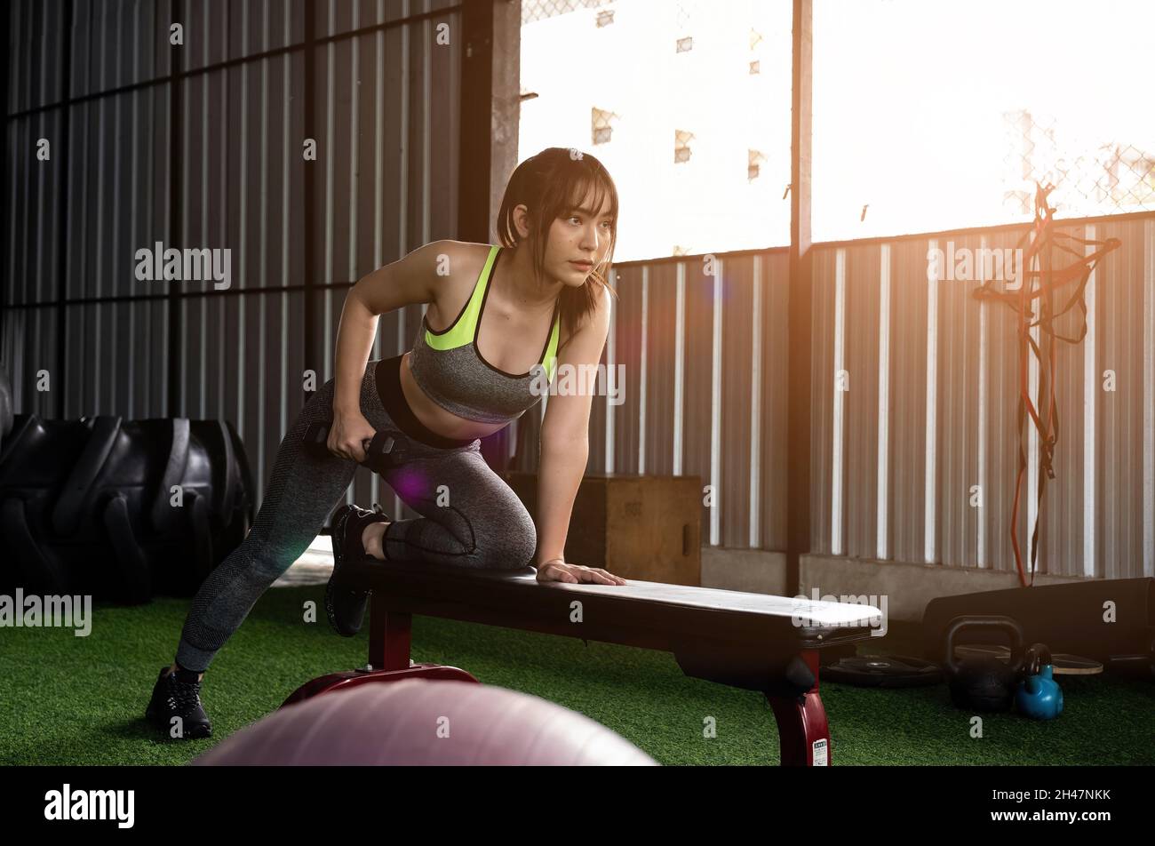 Une femme asiatique stupéfiante se concentre sur lever un haltère à la salle de gym. Musculation Banque D'Images